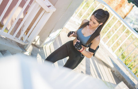 Young sport woman running upstairs on city stairsの写真素材