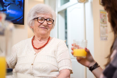 Elderly woman talking with daughter or friend at home.の写真素材