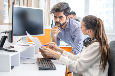 Business people discussing paper document together in office.