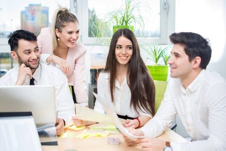 Smiling business people communicating on a meeting in the office.