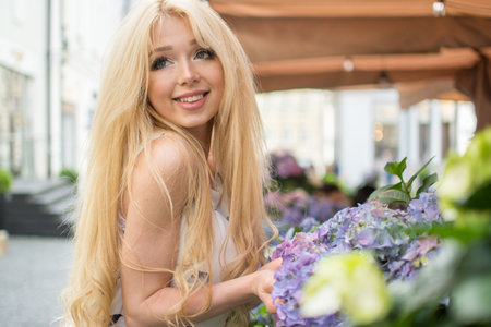 Portrait of beautiful blonde girl on the city street.の写真素材