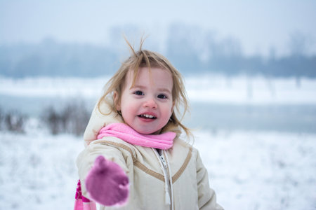 Portrait of happy little girl in winter park.の写真素材