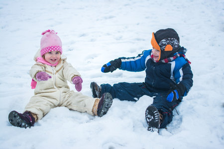 Happy children playing on snow in winter holiday.の写真素材