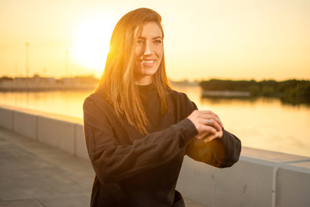Portrait of beautiful young woman doing squat before running outside. Smiling woman warming up before running.の写真素材