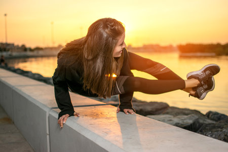 Fit woman practicing yoga, doing arm stand Astavakrasana, asymmetrical arm balance EightAngle Pose near the sea coast.の写真素材