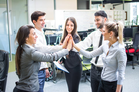 Business people gathering hands in unity celebrating team spirit