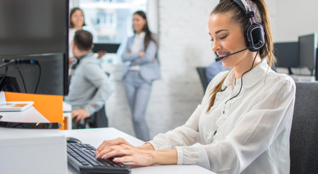 Beautiful female call center operator working on computer in office