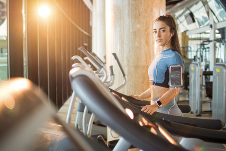 A beautiful athletic young brunette woman in sportswear in the gym