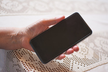 Closeup of senior woman hand holding mobile phone.の写真素材