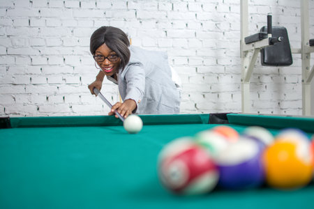 Beautiful young businesswoman playing pool game