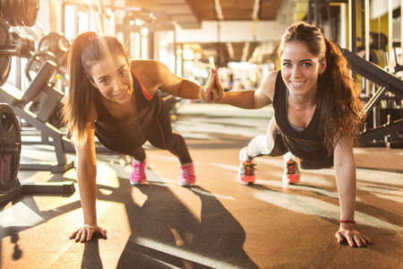 Sporty women working out together at gym.