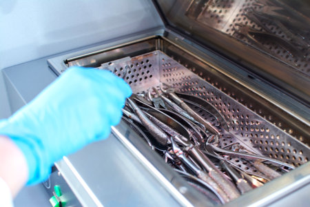 Dentists hands taking out sterilizing medical instruments from autoclave.の写真素材