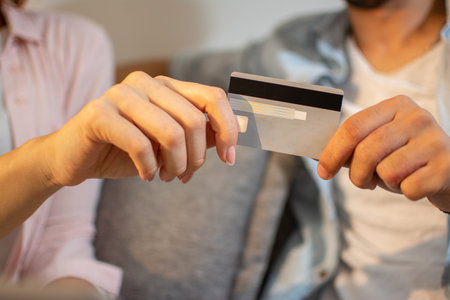 Close up of male and female hands holding bank card together. Man and woman holding credit card in hands togetherの写真素材