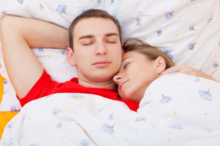 Young sweet couple resting in the bedの写真素材