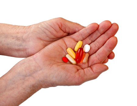 Elderly woman holding pills in her handの写真素材