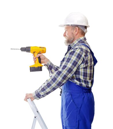Portrait of a handyman, holding a drill on isolated backgroundの写真素材
