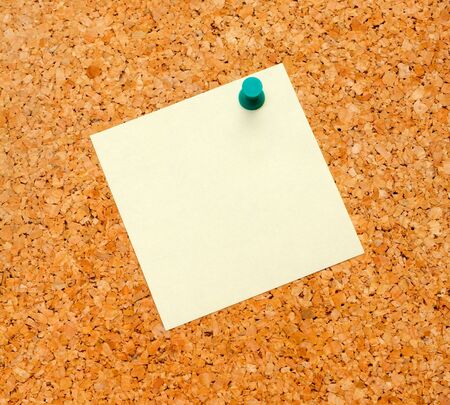 Close up of an empty yellow notice label on cork-boardの写真素材