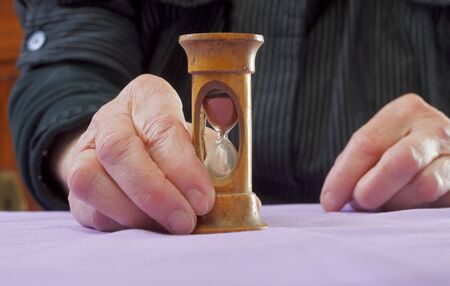 Elderly woman  holding an hourglass with her hands