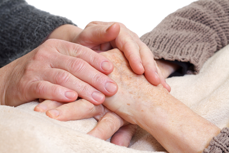 Woman holding elderly hands on isolated の写真素材