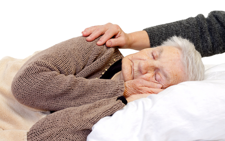 Ill elderly woman lying in the bedの写真素材