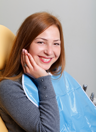 Beautiful woman sitting in a dental chairの写真素材