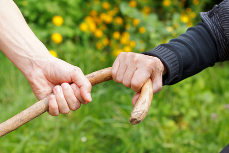 Depressed elderly wrinkled hand holding her caneの写真素材