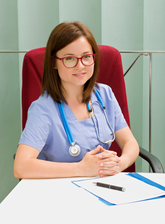 Confident female doctor sitting in his officeの写真素材