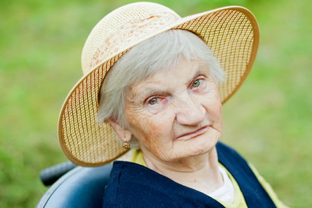 Elderly handicapped woman sitting in a wheelchairの写真素材