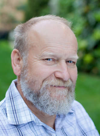 Portrait of an happy elderly man sitting in the garden