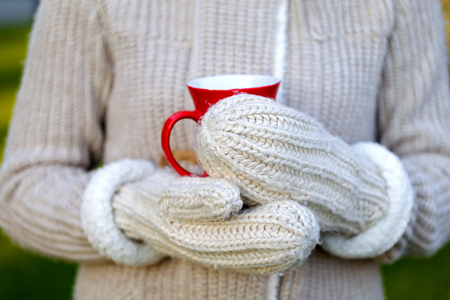 Picture of a woman's hand holding a red coffee mugの写真素材