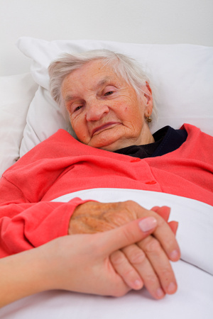 Elderly woman with her caregiver at homeの写真素材