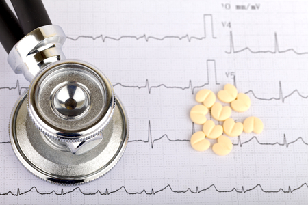 Electrocardiogram graph report with  heart shape pills on itの写真素材