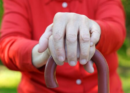 Close up of an elderly hand holding a caneの写真素材