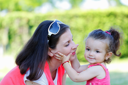 Beautiful young mother playing with her daughterの写真素材