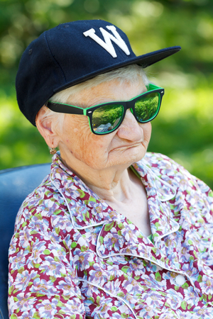 Senior woman wearing sunglasses and baseball capの写真素材