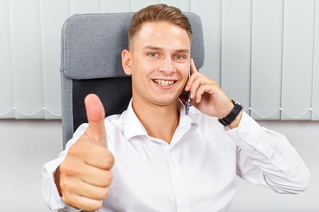 Handsome young businessman receiving an interesting phone callの写真素材