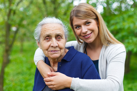 Portrait of a young woman holding her happy grandmotherの写真素材