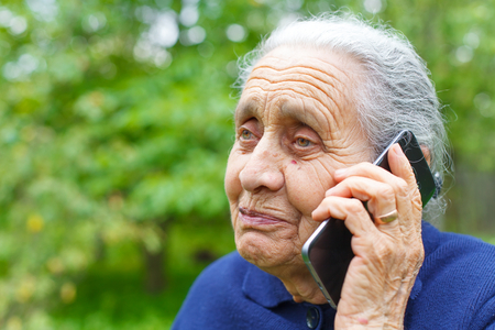 Picture of a happy old woman, talking on cell phoneの写真素材