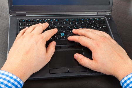 Close up of a man's hand typing on laptopの写真素材