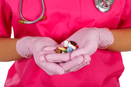 Close-up picture of a doctor's hands with colorful pillsの写真素材