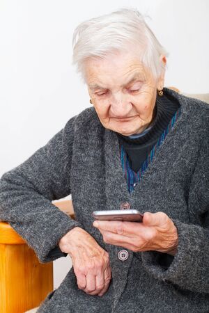 Picture of an old woman holding a cellphone in her handsの写真素材