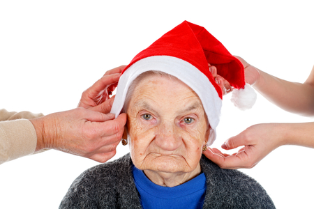Portrait of an elderly woman wearing Santa's hat on an isolated backgroundの写真素材