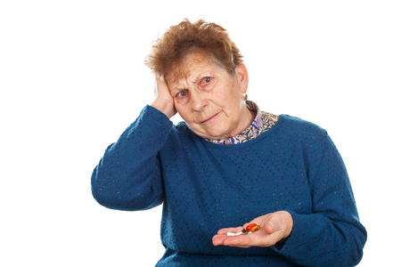 Close up photo of a senior woman's hands, holding her pillsの写真素材