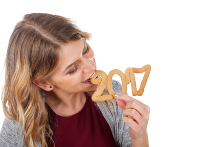 Beautiful young woman biting a 2017'th symbol-cakeの写真素材