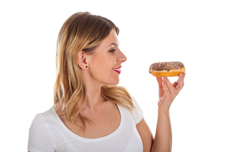 Picture of a happy beautiful woman holding a delicious doughnutの写真素材
