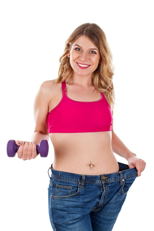 Picture of a sexy young woman holding a dumbbell being happy for her weightlossの写真素材