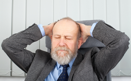 Picture of a tired businessman at his officeの写真素材