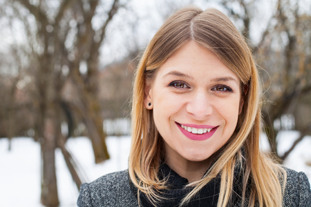 Portrait of a beautiful young woman in the park on wintertimeの写真素材