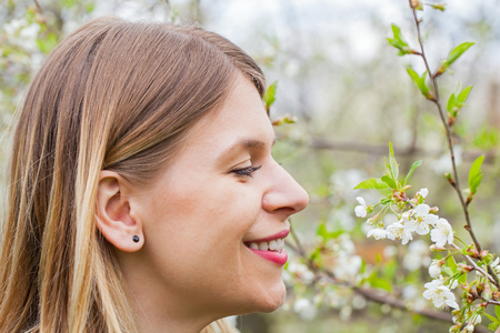 Portrait of an attractive young woman outdoor in blooming garden, springtimeの写真素材