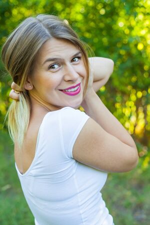 Portrait of sexy young woman smiling back at the camera posing outdoorの写真素材